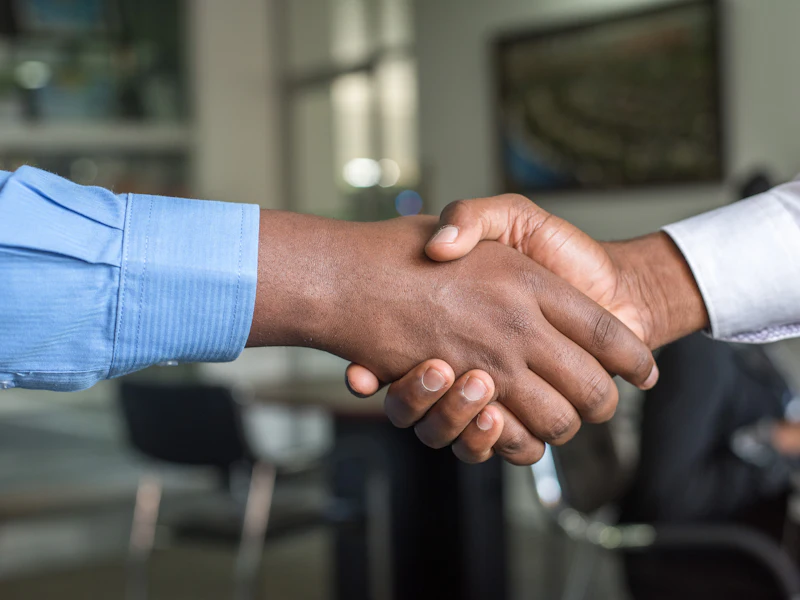 Two people shaking hands over a property deal