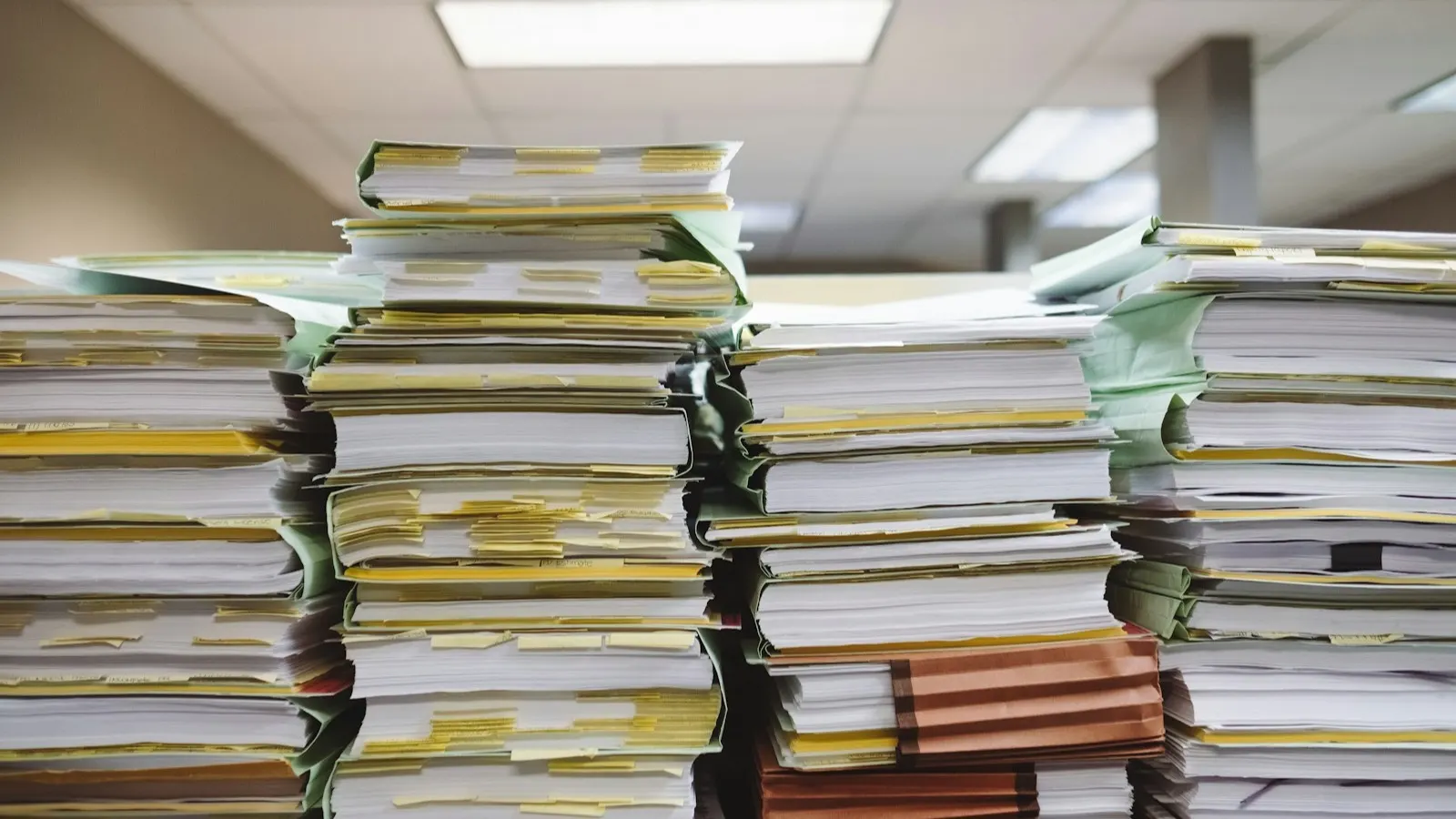 Stacks of paper documents and file folders, the kind of records a UAE bank compliance team asks to see during a KYC review