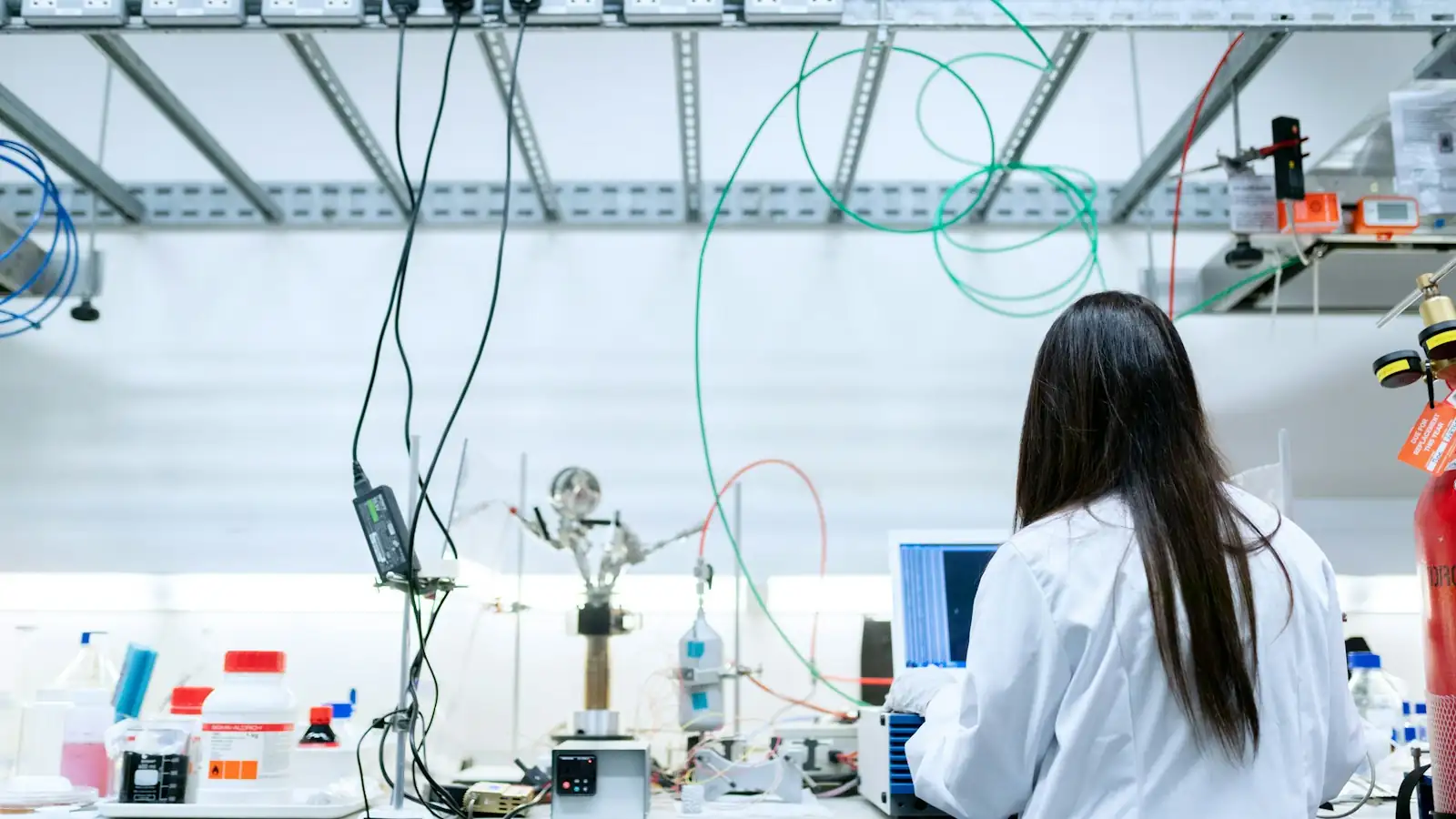Researcher in a laboratory with test equipment and a computer, representing research and development work that can earn the UAE R&D tax credit